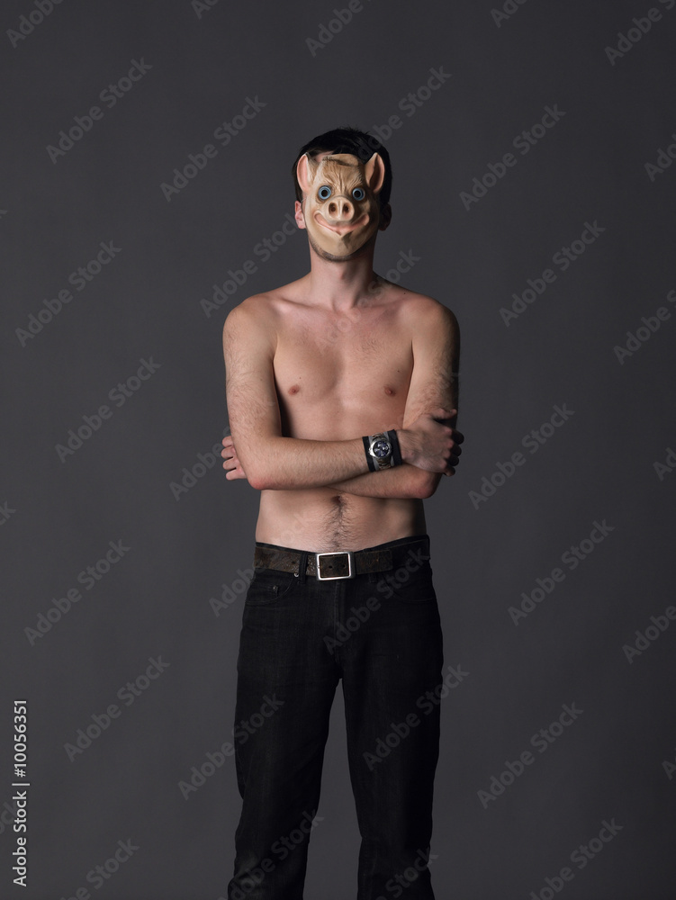 A topless man wears a pig mask
