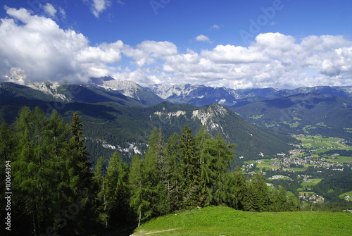 View at alpine mountain peaks with forests and cloudy sky