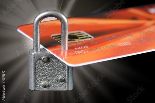 A bank credit card locked by a padlock with flare
