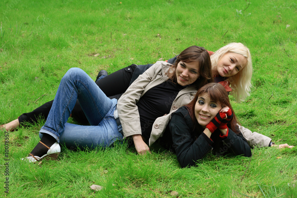 Company of girls having fun on green grass