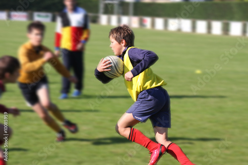Jeune joueur de rugby face à ses adversaires photo