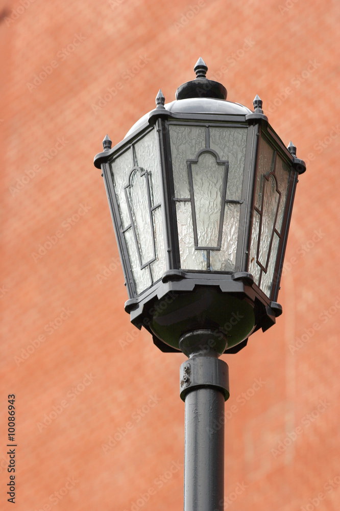 One street lantern against a dim brick wall. One street lantern against a dim brick wall.