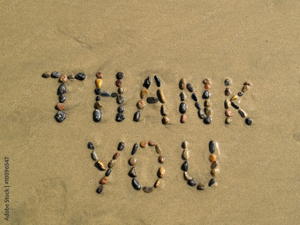 Naklejka premium Thank you phrase written on beach sand