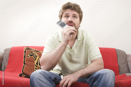 Bored young man is watching TV