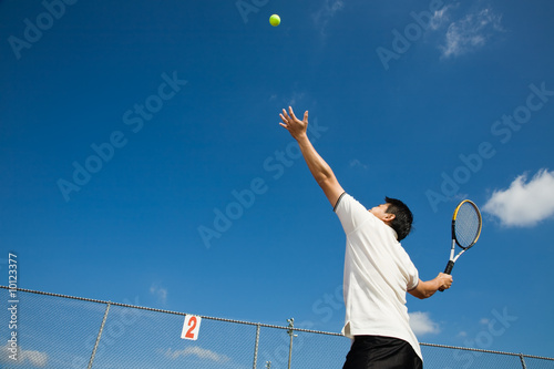 A sporty young asian male playing tennis © arekmalang
