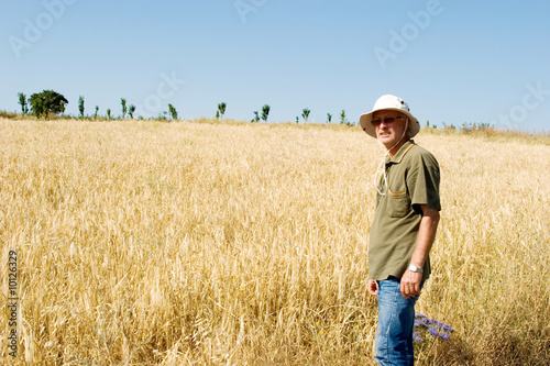 Farmer man working at a wheat field © MaxFX