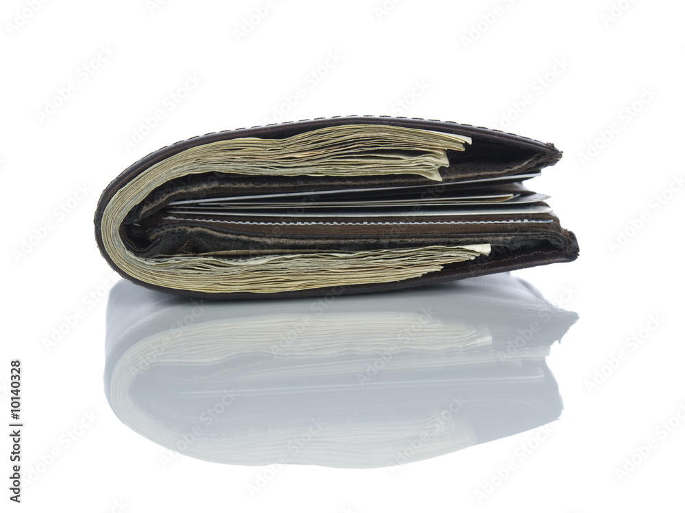 A leather wallet full of dollars isolated on white. A leather wallet full of dollars isolated on white.