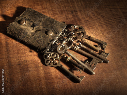 An old leather keyring over a wooden table. photo