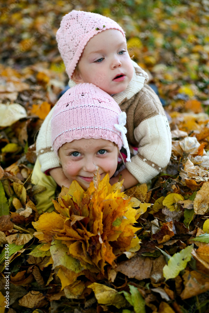 Two sisters playing with leaves in autumn park Two sisters playing with leaves in autumn park