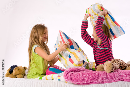 Two young children enjoying their colorful bed