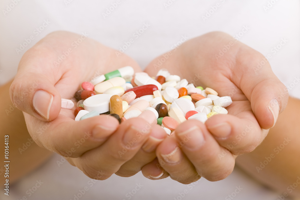 Viele bunte Tabletten und Pillen in einer Hand Viele bunte Tabletten und Pillen in einer Hand