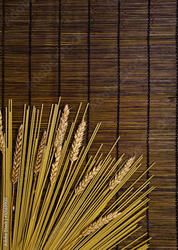 brown bamboo board background with italian pasta and grain
