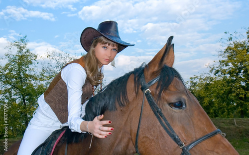 Pretty young woman riding beautiful horse.