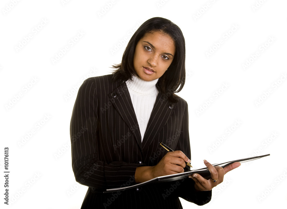 An Indian woman in business suit writing in a notebook An Indian woman in business suit writing in a notebook