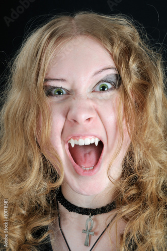 Screaming young vampire girl, on black background