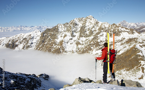 Male ski-climber at the summit of his climbing