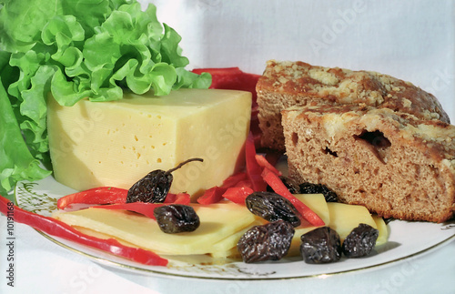 Cheese, olives, lettuce, paprica and farm bread on the plate photo