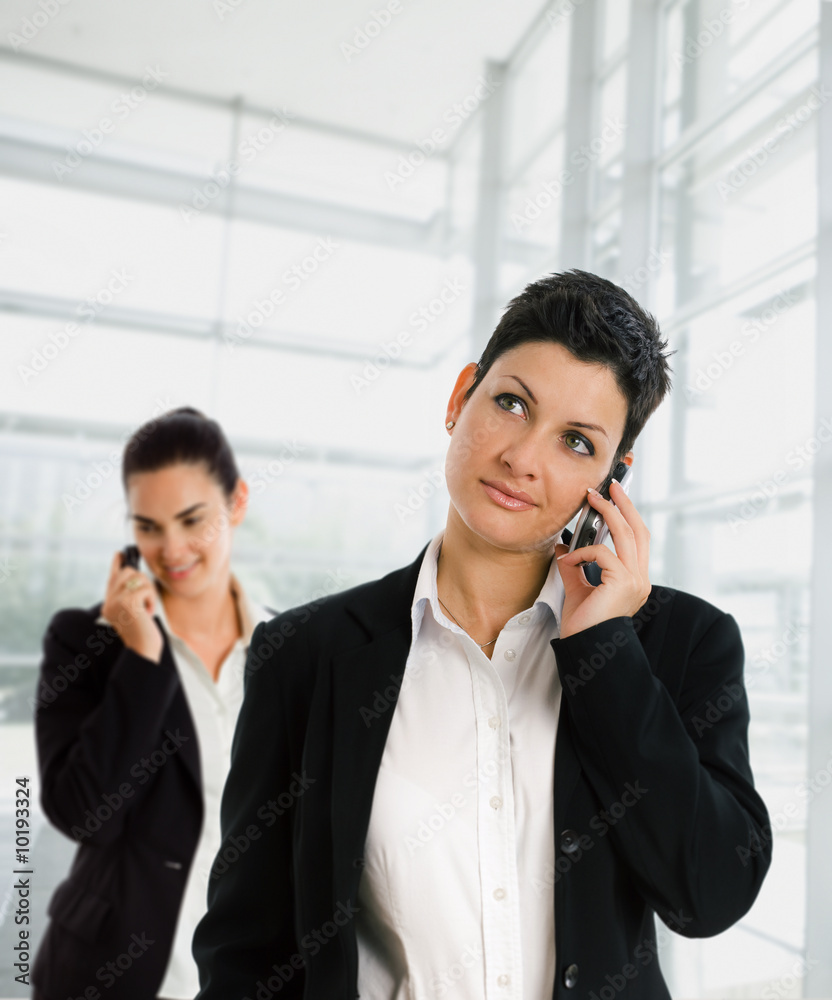 Businesswomen calling on mobile phone at office. Businesswomen calling on mobile phone at office.