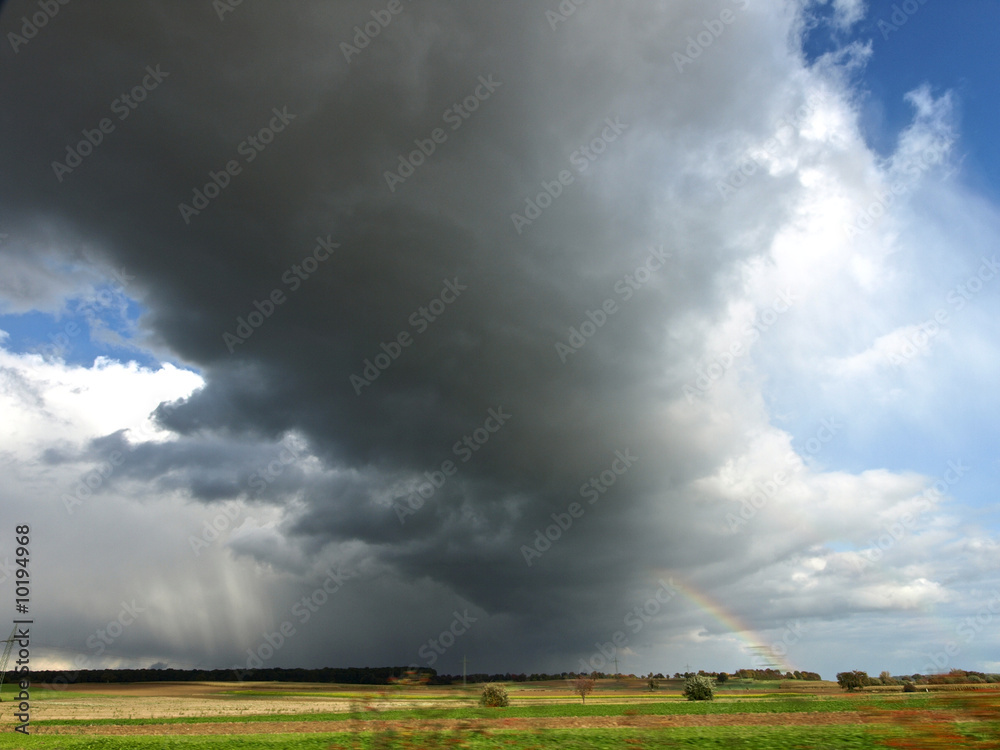 Gewitterwolke und Regenbogen ziehen übers Land Gewitterwolke und Regenbogen ziehen übers Land