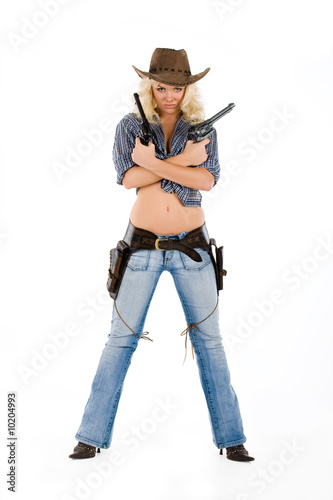 Young blonde woman in cowboy clothes with guns