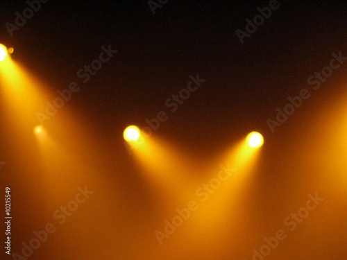 Spots colorés jaunes sur une scène de spectacle.