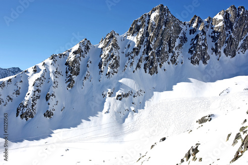 Schneebedeckte Berge mit einem Hang voller Skispuren