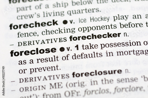 A close up of the word foreclose from a dictionary