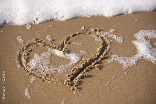 A heart drawn into the wet sand at the beach.