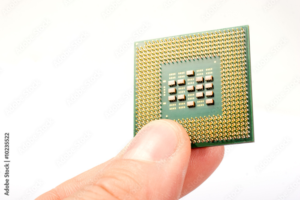 Fingers holding processor unit over white Fingers holding processor unit over white