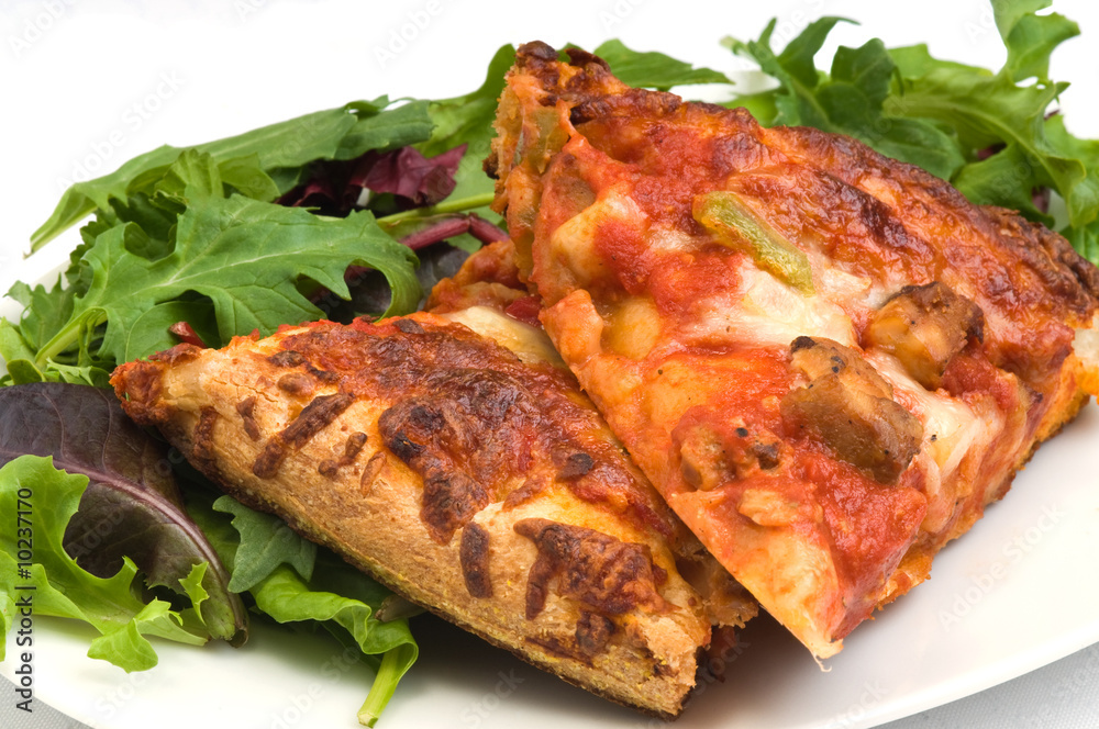 Slices of homemade pizza with a mixed salad. Slices of homemade pizza with a mixed salad.