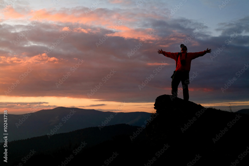 An image of silhouette of a man on a rock