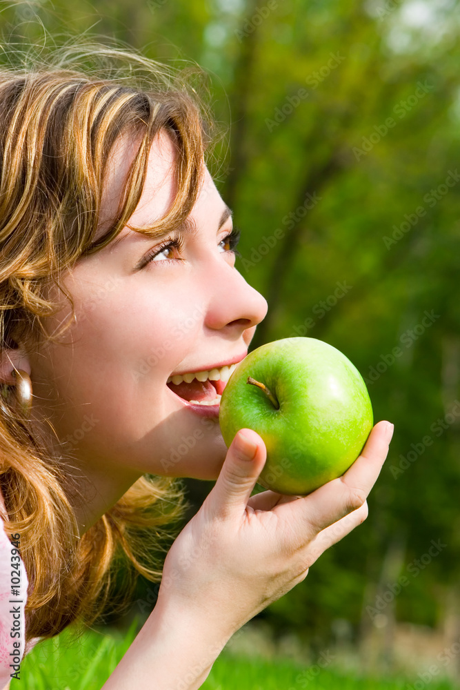 pretty woman eating green apple on the summer glade pretty woman eating green apple on the summer glade