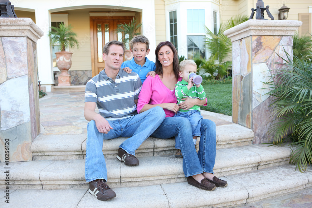 A happy family having fun outdoors in front of their home A happy family having fun outdoors in front of their home