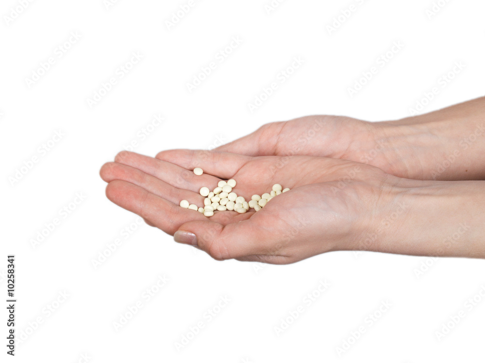 In open hands white tablets on a white background lie
