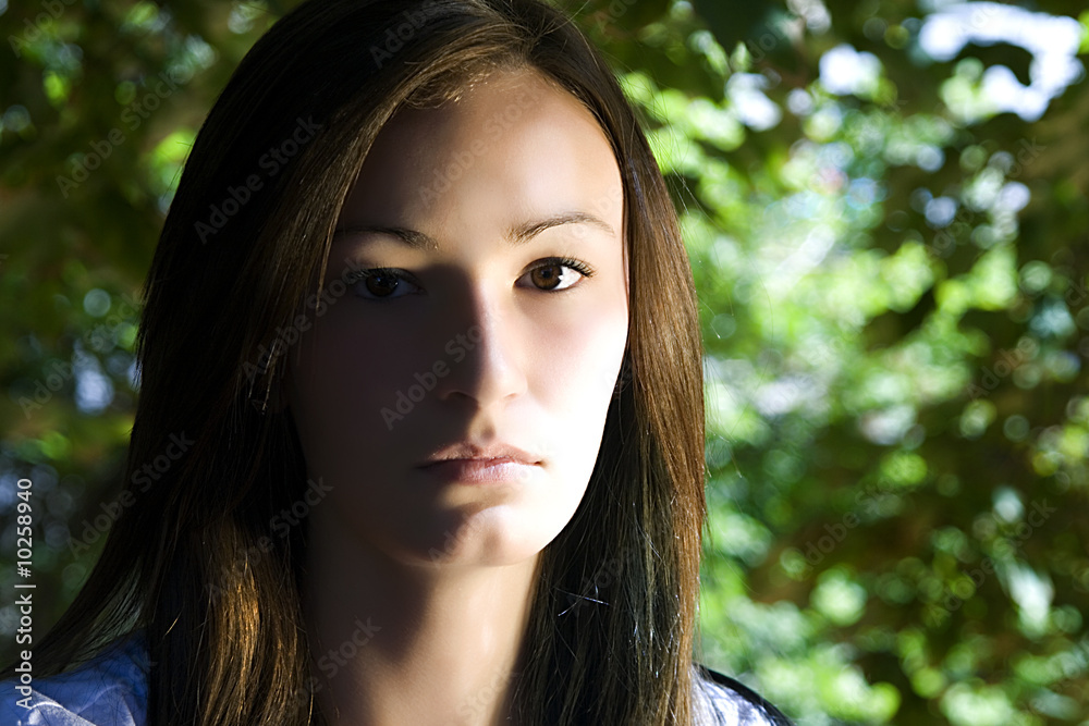 Close up on a Beautiful Teenager with Leaves in the Background Close up on a Beautiful Teenager with Leaves in the Background