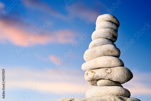 Stack of balanced pebbles  stones against colorful blue sky