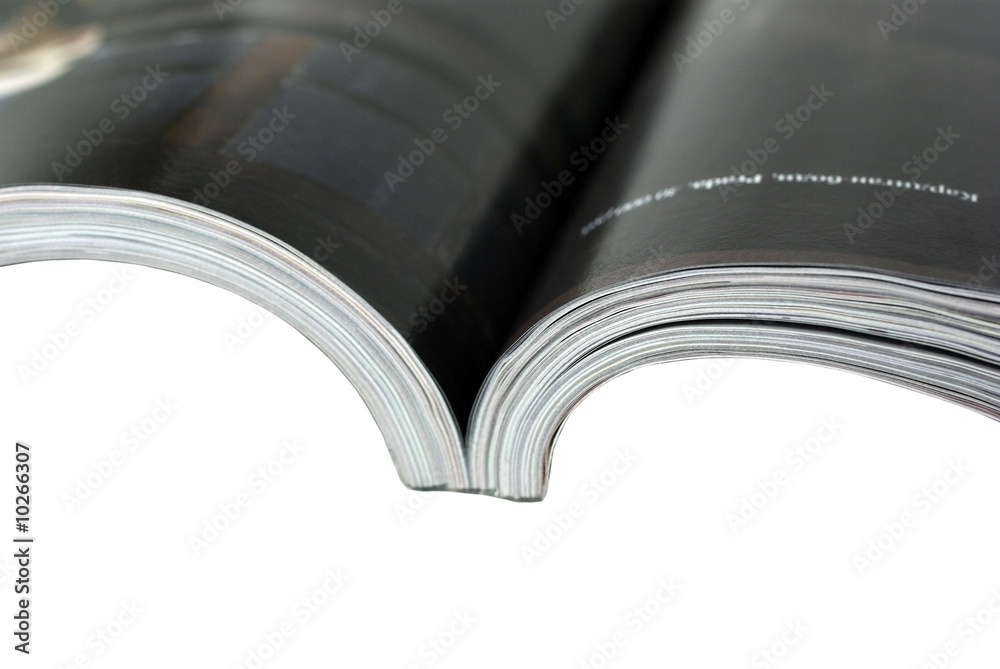 Opened magazine close-up on white background.