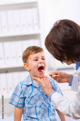 Senior female doctor examining little child boy. photo