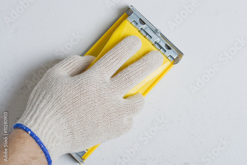 Apartment repair. Processing of a wall by an sandpaper. photo