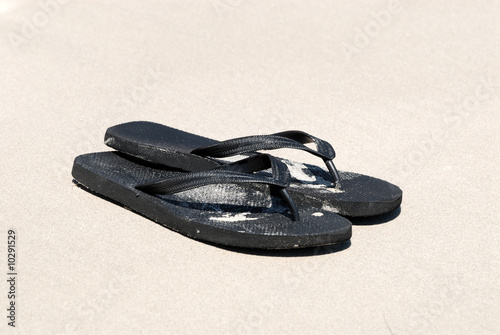 Black flip-flops on the beach