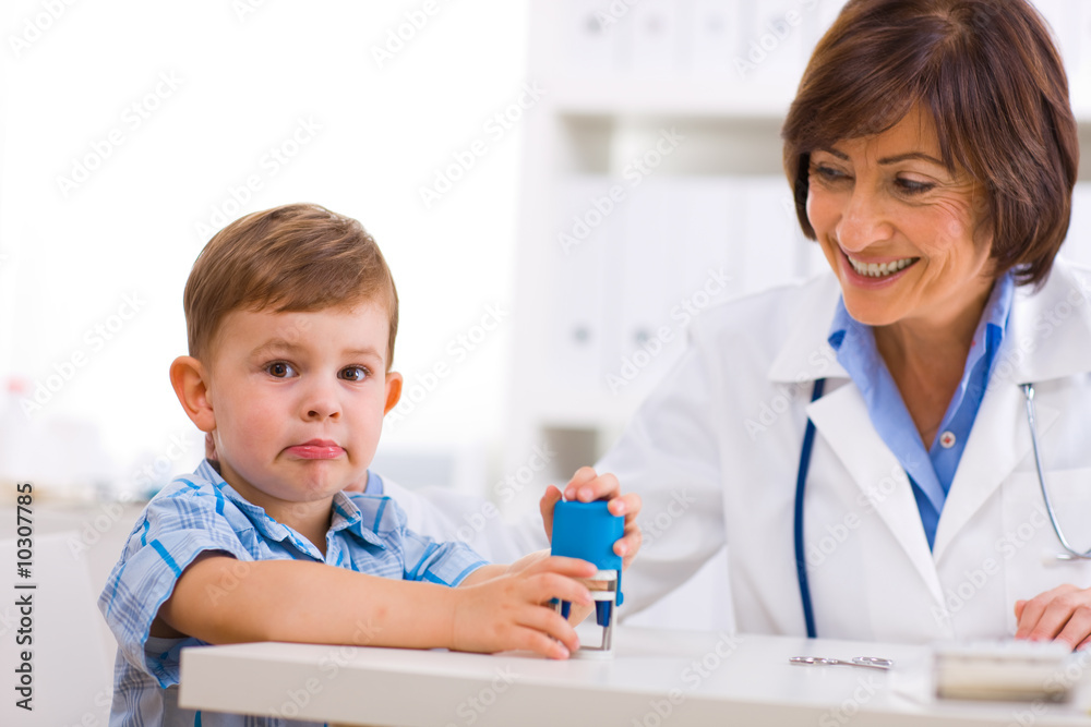 Senior female pediatrician playing with child at doctors office Senior female pediatrician playing with child at doctors office