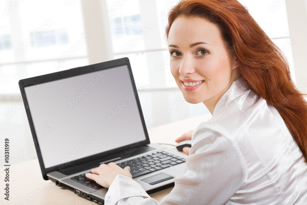 Portrait of beautiful secretary while typing on the laptop Portrait of beautiful secretary while typing on the laptop