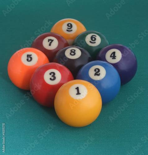 nine billiard balls on a green table