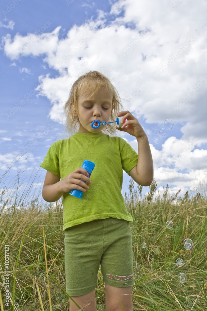 Children blowing bubbles on summer meadow Children blowing bubbles on summer meadow