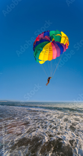 Man is parasailing in the blue sky