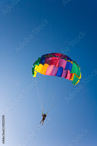 Man is parasailing in the blue sky
