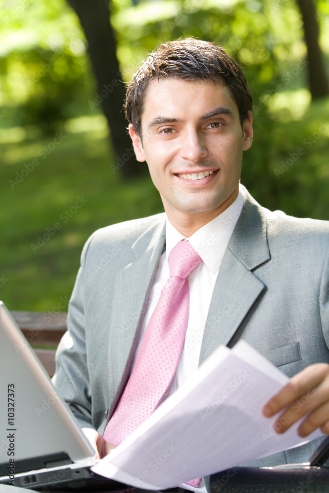Happy businessman working with laptop outdoors Happy businessman working with laptop outdoors