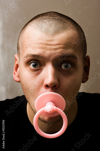 immaturity concept - adult man with dummy in the mouth