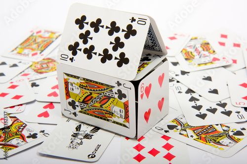 A house made of playing cards sitting on top of other cards