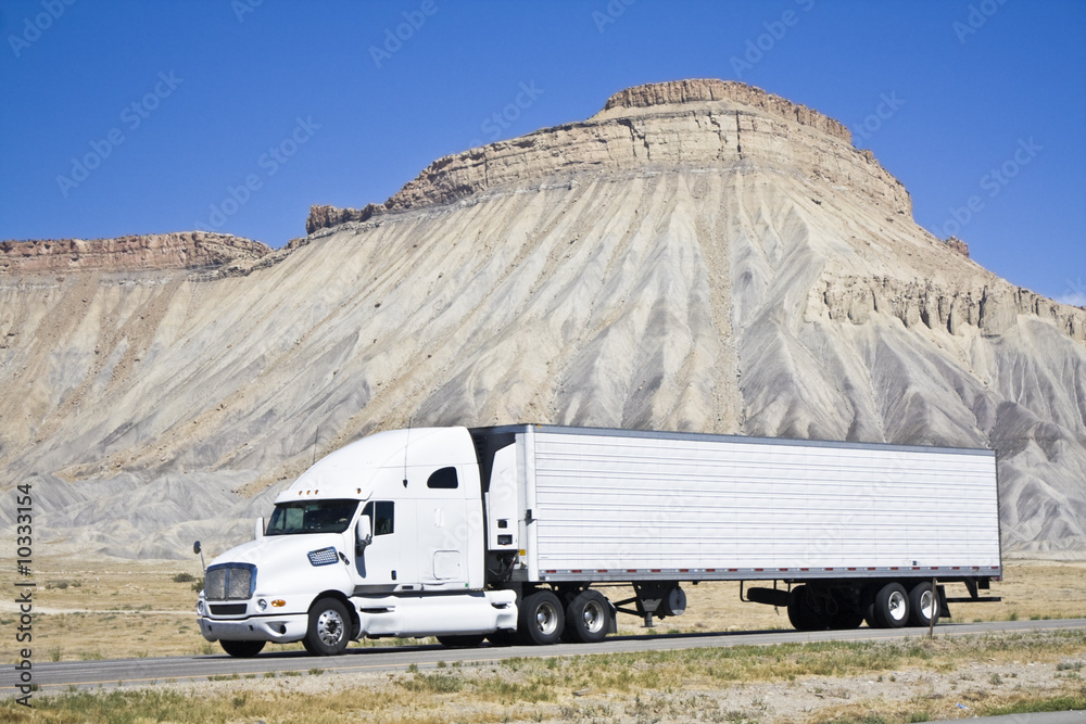 White semi truck driving in Colorado